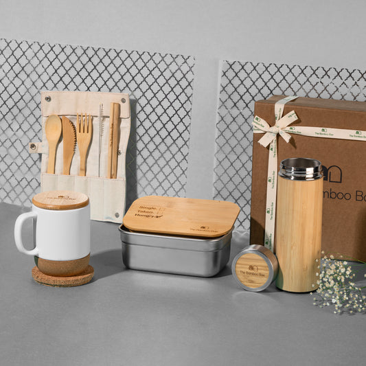 Sustainable gift hamper with bamboo cutlery set, ceramic mug with cork base, bamboo lunch box, bamboo bottle, and round cork coaster – eco-friendly gifting set for daily use.