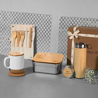 Sustainable gift hamper with bamboo cutlery set, ceramic mug with cork base, bamboo lunch box, bamboo bottle, and round cork coaster – eco-friendly gifting set for daily use.