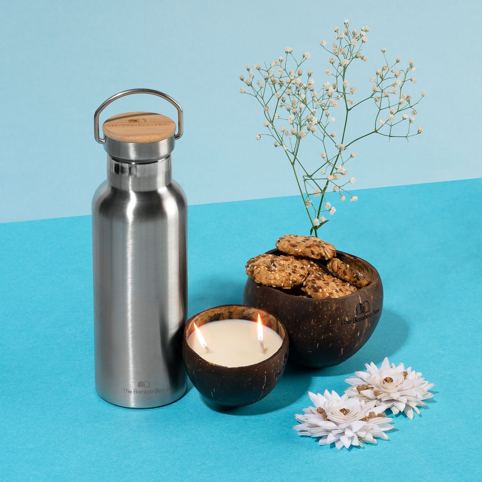 Eco-friendly gift set with stainless steel thermos bottle with bamboo lid, coconut soy candle, and coconut shell bowl – sustainable gifting option.