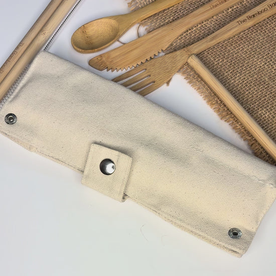 Eco-friendly bamboo cutlery set with spoon, fork, knife, straw, cleaner, and canvas pouch – reusable and sustainable travel dining kit.