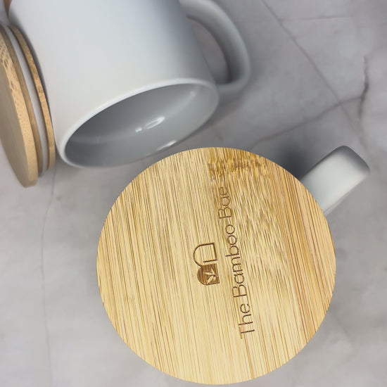 Eco-friendly porcelain coffee mug with cork base and bamboo lid – reusable sustainable drinkware.